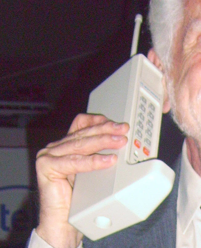 A Motorola DynaTAC mobile phone on display — the 'brick phone' era.